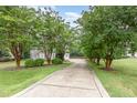 Long driveway lined with mature trees, leading to a home with professional landscaping and a private setting at 50 Pebble Creek Dr, Franklinton, NC 27525