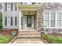 Welcoming front entrance with a detailed glass door, stone accents, and meticulously maintained landscaping at 50 Pebble Creek Dr, Franklinton, NC 27525