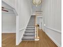 Grand foyer with hardwood floors, carpeted stairs, high ceilings, and decorative chandelier at 5121 Ten Point Trl, Wake Forest, NC 27587