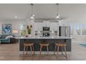 Modern kitchen with white cabinets, stainless appliances and an oversized central island with seating at 518 Toran Dr, Wake Forest, NC 27587
