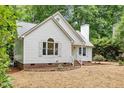 View of the home's front facade showing the white siding, brick foundation, and professionally landscaped front yard at 702 Sanderson Dr, Durham, NC 27704