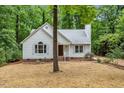 Charming home boasts brown straw lawn, white siding, brick foundation, mature trees, and professionally landscaped front yard at 702 Sanderson Dr, Durham, NC 27704