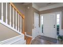 Inviting foyer with white trim, neutral paint, tile flooring, and a staircase at 7244 Galon Glen Rd, Raleigh, NC 27613