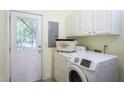 Functional laundry area with washer, dryer, and ample overhead cabinet storage at 7244 Galon Glen Rd, Raleigh, NC 27613