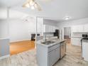 Open-concept kitchen with a large island, stainless steel appliances, granite countertops and bright lighting at 8312 Bellingham Cir, Raleigh, NC 27615