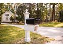 Quaint black mailbox on a white decorative post, adding to the home's curb appeal at 9200 Lake Carol Dr, Zebulon, NC 27597
