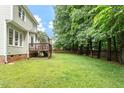 Spacious backyard featuring a wooden deck, lush green lawn, and mature trees at 933 Richland Ridge Dr, Wake Forest, NC 27587
