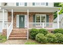 Welcoming front porch with brick accents, white railings, and a decorative front door at 933 Richland Ridge Dr, Wake Forest, NC 27587