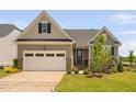 Charming single-Gathering home featuring a two-car garage, neutral siding, and professionally landscaped front yard at 1002 Gilly Ct, Durham, NC 27703