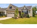 Charming single-Gathering home featuring a two-car garage, neutral siding, and professionally landscaped front yard at 1002 Gilly Ct, Durham, NC 27703