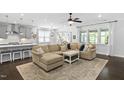 Open-concept living room with a large sectional couch and abundant natural light streaming through the windows at 1002 Gilly Ct, Durham, NC 27703