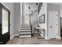 Bright foyer with an open staircase, modern railing, wood flooring, and contemporary design at 1003 E Sterlington Pl, Apex, NC 27502