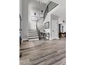 Bright foyer with an open staircase, modern railing, wood flooring, and contemporary design at 1003 E Sterlington Pl, Apex, NC 27502