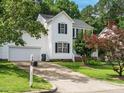A charming white home with a two-car garage and a long driveway at 1010 Starita Ct, Apex, NC 27502
