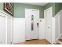 Bright entryway with white paneled walls, a decorative front door, and hardwood flooring at 1015 Manchester Dr, Cary, NC 27511
