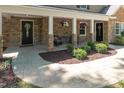 Inviting covered front porch with stone columns, hanging flower baskets, and a seating area at 1015 Manchester Dr, Cary, NC 27511