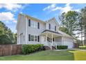 Beautifully maintained two-story home featuring a manicured lawn and a cozy, covered front porch at 105 Tactical Dr, Bunnlevel, NC 28323