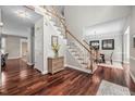 Welcoming foyer boasts hardwood floors, staircase with white railings, and view into dining room at 111 Gingergate Dr, Cary, NC 27519
