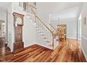 Elegant staircase with wooden banister, carpeted steps and beautiful hardwood floors at 111 Gingergate Dr, Cary, NC 27519