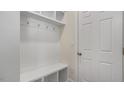 Entryway showing the built-in coat rack, storage, and hooks next to a white door at 121 Gilmer St, Fuquay Varina, NC 27526