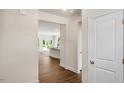 Hallway view opening to the kitchen with stainless steel appliances, white cabinetry, and dark countertops at 121 Gilmer St, Fuquay Varina, NC 27526