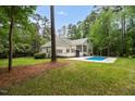 Backyard featuring in-ground pool, wooden deck, and spacious lawn area at 12301 Hardee Rd, Raleigh, NC 27614
