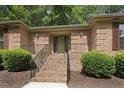 Brick home entrance with brick steps, black handrails, and neatly trimmed bushes at 136 Sycamore St, Cary, NC 27513