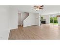 Bright living room with light wood flooring, a modern ceiling fan, and an open floor plan leading to the kitchen at 1534 Glenwater Dr, Cary, NC 27519