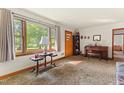 Bright living room featuring a large window, classic piano, and neutral carpeting at 1593 E Washington Ave, Creedmoor, NC 27522