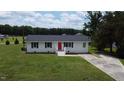 Aerial view of single-story home with red front door, white exterior, black shutters, and a spacious green yard at 1676 Richardson Bass Rd, Kenly, NC 27542