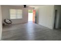Bright and airy living room featuring wood-look flooring, neutral walls, and a view of the front yard through a window at 1676 Richardson Bass Rd, Kenly, NC 27542