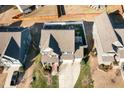 Aerial view of a two-story home with a well-maintained lawn, a two-car garage, and a basketball hoop in the backyard at 1716 Longmont Dr, Wake Forest, NC 27587