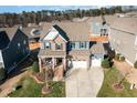 A stunning aerial view of this two-story home with a two-car garage, manicured lawn, and cozy front porch at 1716 Longmont Dr, Wake Forest, NC 27587