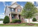 Charming two-story home featuring brick and siding, a covered porch, a two-car garage, and landscaped front yard at 1716 Longmont Dr, Wake Forest, NC 27587