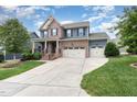 Charming two-story home featuring brick and siding, a covered porch, a two-car garage, and landscaped front yard at 1716 Longmont Dr, Wake Forest, NC 27587