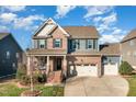 Charming two-story home with a brick and gray siding, an inviting front porch, and well-manicured landscaping at 1716 Longmont Dr, Wake Forest, NC 27587