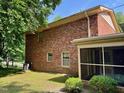 The red brick of the home is complemented by the green, landscaped backyard at 1818 Brookrun Rd, Henderson, NC 27536