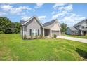 Well-maintained single-story home featuring a green lawn and a two-car garage and vinyl siding at 1828 Wellspring Ct, Graham, NC 27253