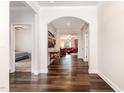 Bright hallway with hardwood floors, arched doorways, and views into the living room and bedroom at 1828 Wellspring Ct, Graham, NC 27253