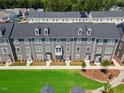 An aerial view highlights the townhome community, with lush green spaces between the units at 2006 Nola Ln, Durham, NC 27713