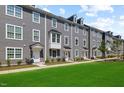 Well-maintained gray townhomes showcase manicured lawns and inviting front doors at 2006 Nola Ln, Durham, NC 27713