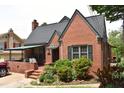 Attractive brick home with a cozy covered porch, surrounded by mature landscaping and a welcoming entrance at 2210 Hope St, Raleigh, NC 27607