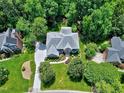 Birds eye view of brick home showing the property lines, surrounding trees, and manicured lawn at 225 Midenhall Way, Cary, NC 27513