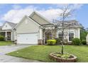 Inviting home exterior with well-kept lawn, charming landscaping and a two car garage at 2410 Kinglass Dr, Fuquay Varina, NC 27526