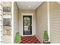 Charming entryway featuring a patterned rug, stylish door, and manicured greenery at 2410 Kinglass Dr, Fuquay Varina, NC 27526
