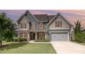Charming two-story home featuring a manicured lawn, attached garage, and inviting front porch at 2507 Belvinwood Dr, Fuquay Varina, NC 27526