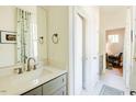 Well-lit bathroom featuring a modern vanity, stylish mirror, and adjacent access to other rooms at 2658 Lawndale Ave, Durham, NC 27705