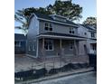 Side view of a gray, two-story home featuring modern design and a cozy, covered front porch at 2658 Lawndale Ave, Durham, NC 27705
