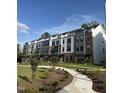 Modern townhouse exteriors feature beautiful landscaping, sidewalks, and a combination of siding and brick at 3104 Kempthorne Rd # 48, Cary, NC 27519
