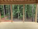 View from the new wooden porch, with exposed beam framework, into the lush greenery of the forest at 3905 Cedar Knolls Dr, Youngsville, NC 27596